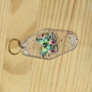 Green butterfly with flowers on clear sparkle key chain